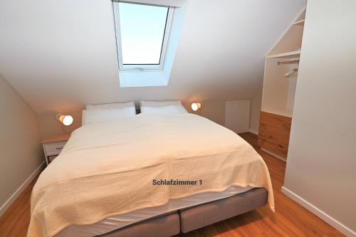 a bedroom with a white bed with a window at Residenz R1 App 2 in Behrensdorf
