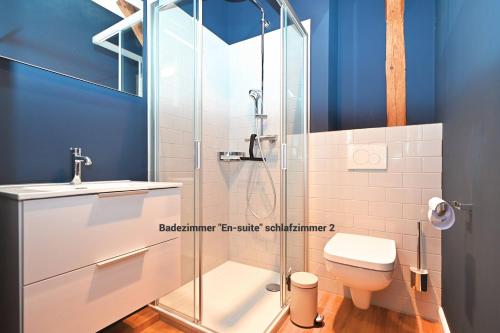 a bathroom with a toilet and a glass shower at Residenz R1 App 4 in Behrensdorf