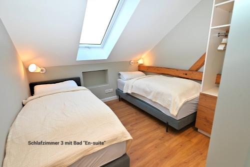 a attic bedroom with two beds and a window at Residenz R1 App 4 in Behrensdorf