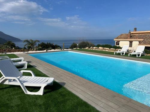 a swimming pool with lounge chairs next to a house at Apt Perterrepermari a 2 Km Da Riserva Dello Zingaro in Scopello