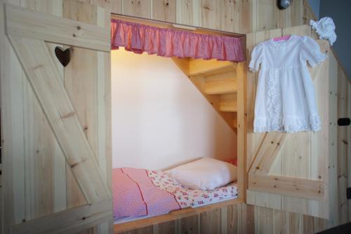 a bedroom with a bunk bed with a dress on it at Erfgoed & Logies Den Heijkant in Moergestel