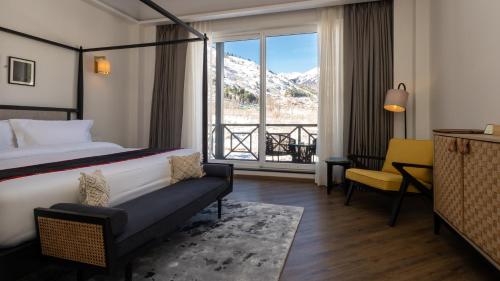 a hotel room with a bed and a large window at Nivasana Manali - A Luxury Boutique Hotel in Manāli