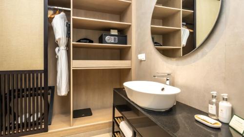 a bathroom with a sink and a mirror at Nivasana Manali - A Luxury Boutique Hotel in Manāli