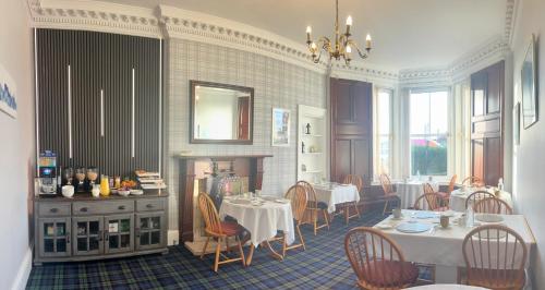 a dining room with two tables and chairs at Brig O'Doon Guest House in Edinburgh