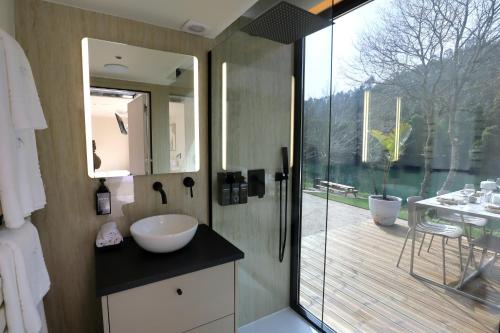 a bathroom with a sink and a large glass window at VILLA La Finca in Vieira do Minho