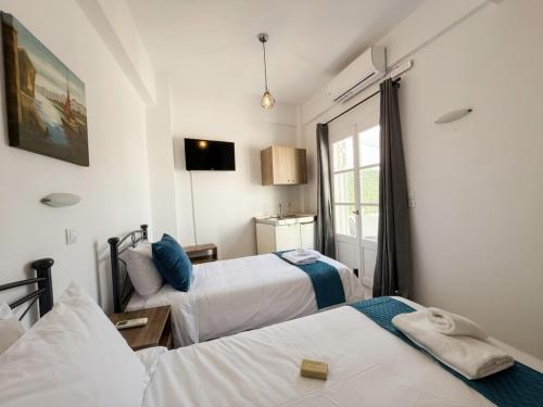 a hotel room with two beds and a window at Aegean Nest Beach Studios - Adults only in Monolithos
