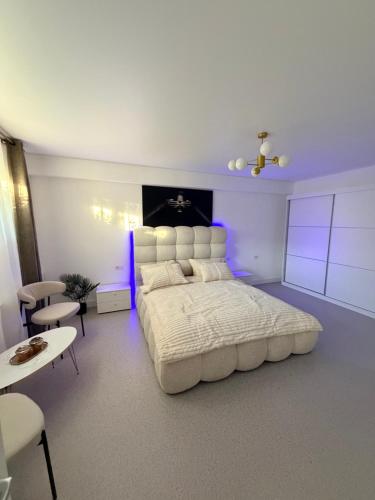 a large bedroom with a large white bed and purple lighting at LVO Studio in Bîrlad
