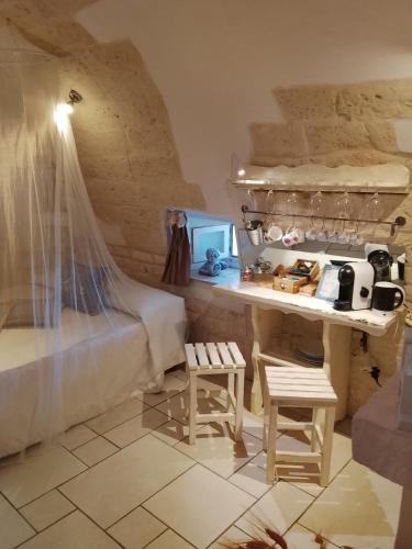 a room with a bed and a table and chairs at Dimora Bianca Ostuni in Ostuni