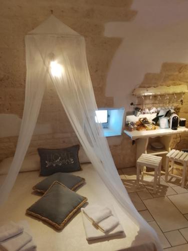 a bedroom with a bed with a mosquito net at Dimora Bianca Ostuni in Ostuni