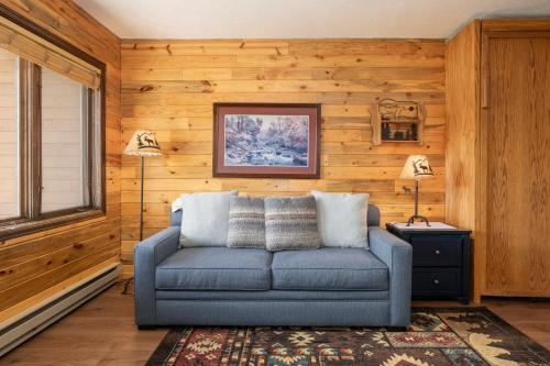 a blue couch in a room with wooden walls at 564 Silvercreek Inn in Granby