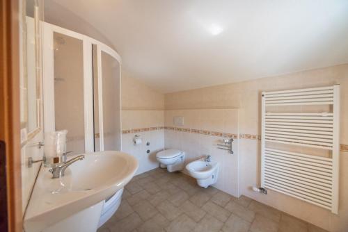 a bathroom with a sink and a toilet and a tub at Agriturismo La Part in San Zeno di Montagna