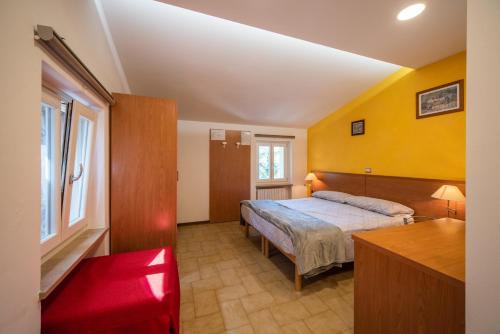 a bedroom with a bed and yellow walls at Agriturismo La Part in San Zeno di Montagna