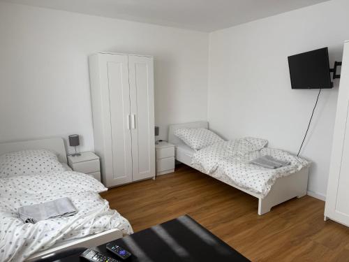 a white room with two beds and a tv at Ferienwohnung LuMa in Rottenacker in Rottenacker