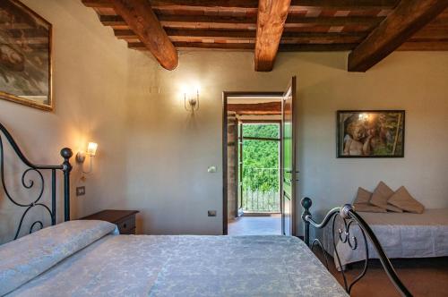 a bedroom with two beds and a door to a patio at Villa Badia, large villa in Umbria with private pool in Città di Castello