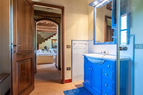 a blue bathroom with a sink and a mirror at Villa Badia, large villa in Umbria with private pool in Città di Castello