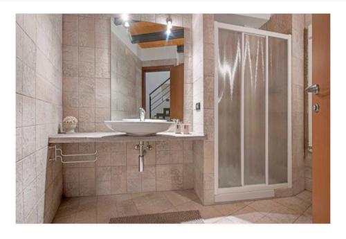 a bathroom with a sink and a mirror at La casa dei Pasqui' in Bollone