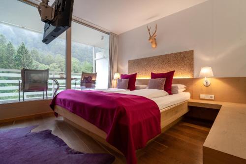 a bedroom with a large bed and a large window at Valavier Aktivresort in Brand