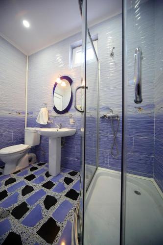 a bathroom with a shower and a sink and a toilet at Hotel Harmony in Kutaisi