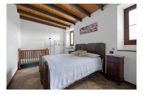 a bedroom with a bed and a crib at La casa dei Pasqui' in Bollone