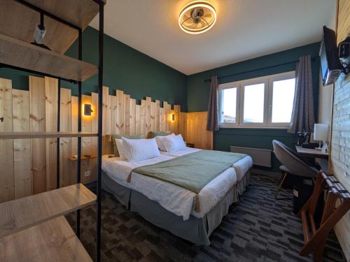 a bedroom with a bed in a room with green walls at Logis Hotel Eden Lac in Savines