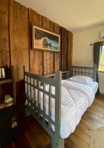 a bedroom with a bed with a wooden wall at Aonang Green Tree in Ao Nang 