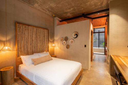 a bedroom with a white bed and a window at The Quiet Garden in Jacó
