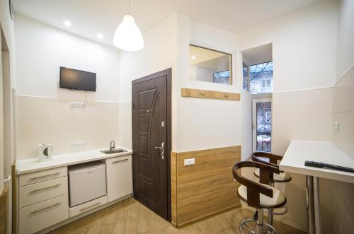 リヴィウにあるMini Smart apartments on Viacheslava Chornovola Avenue 21-1のキッチン(シンク、デスク、椅子付)