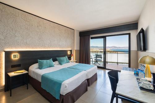a hotel room with a bed and a view of the ocean at Hotel Puente Real in Torremolinos