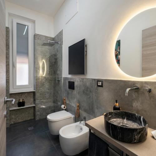 a bathroom with a sink and a toilet and a tub at Janua Jungle House in Genoa