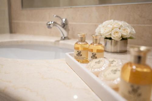 a bathroom sink with two bottles of oils on it at Grand Hôtel Moderne in Lourdes