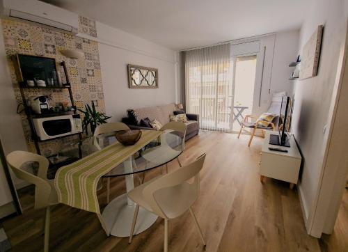 a living room with a glass table and chairs at Residencial Colibrí in Cambrils