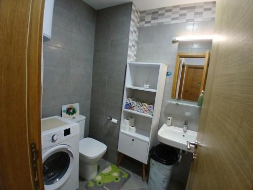 a small bathroom with a washing machine and a sink at Jednosoban stan Tivat in Tivat