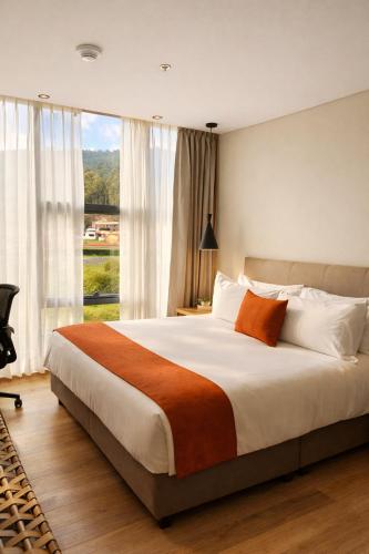 a bedroom with a large bed with a large window at Hotel B3 Sibelius in Chía