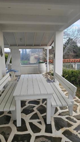 a white picnic table sitting on a patio at White and Blue in Mesimvría