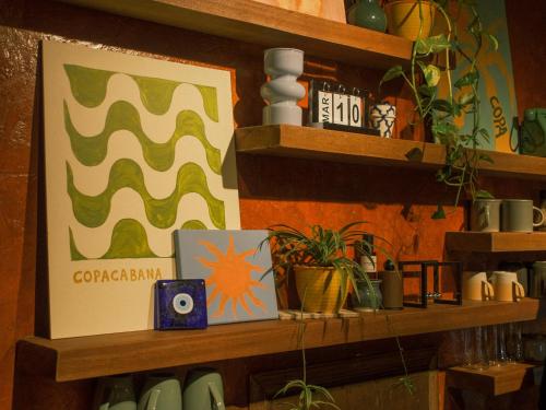 a shelf with plants and a picture on it at Copacabana Siargao Boutique Hotel & Artcafé in General Luna