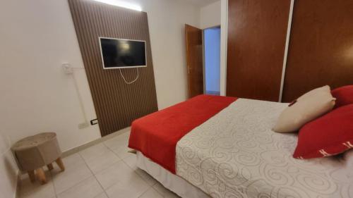 a bedroom with a bed and a television on a wall at Home in Río Cuarto