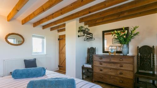 a bedroom with a bed and a dresser and a mirror at Pen Bonc in Moelfre