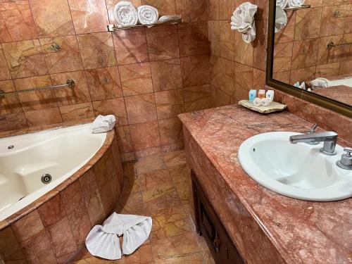 a bathroom with a sink and a tub at Hotel Real de Don Juan in Tepic
