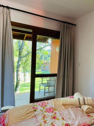 a bedroom with a bed and a large window at hotel fazenda ctk in Santa Cruz do Sul