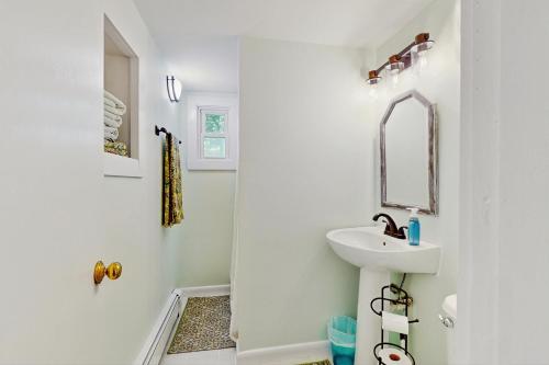 a white bathroom with a sink and a mirror at 2 Mi to Dowses Beach! Couples Haven in Osterville in Osterville