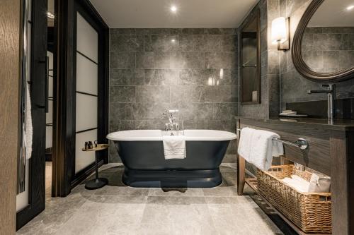 a bathroom with a bath tub and a sink at Dakota Manchester in Manchester