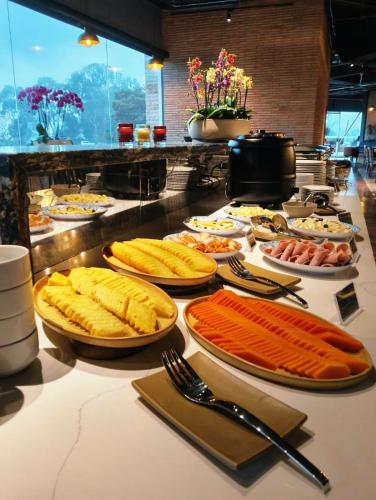 a buffet with many plates of food on a table at Hotel B3 Sibelius in Chía