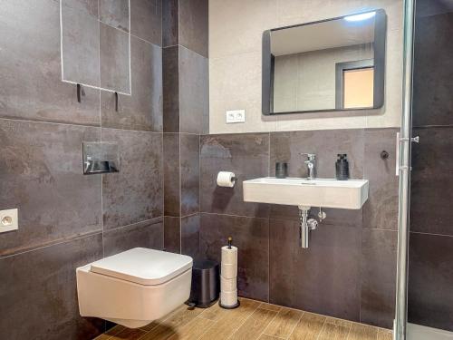 a bathroom with a toilet and a sink and a mirror at Eurovea Tower Apartment 27th floor, Luxury bed VISPRING Baronet Superb in Ovsište