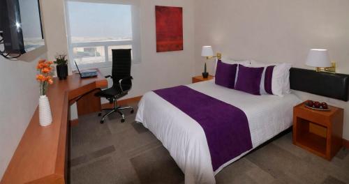 a hotel room with a bed and a desk and a computer at Hotel Lois Express Monterrey Aeropuerto La Fe in Monterrey