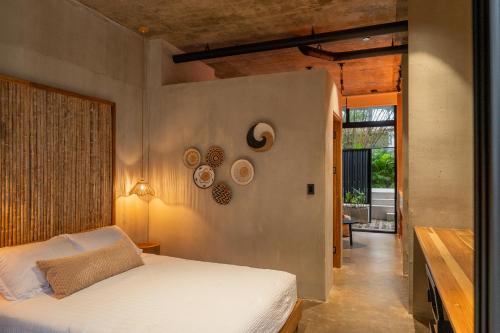 a bedroom with a bed and a wall with plates on it at The Surfer's Base in Jacó