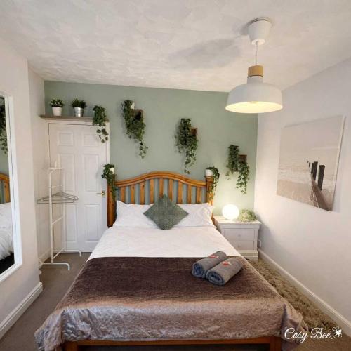a bedroom with a bed with plants on the wall at Cosy Bee - Freemantle Solent Lodge in Southampton