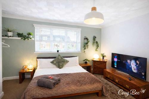 a bedroom with a large bed and a flat screen tv at Freemantle Solent Lodge in Southampton