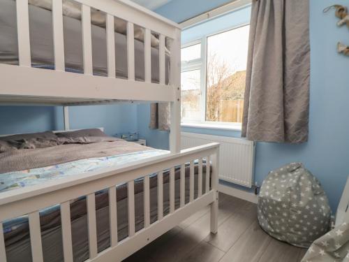 a bedroom with a bunk bed and a window at Mikes Place On The Cove in Rhyl