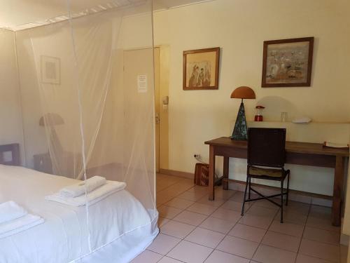 a bedroom with a desk and a bed and a desk at Villa Yiri Suma in Ouagadougou