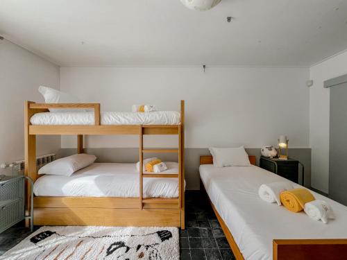 two bunk beds in a room with white walls at Casa das Rampas - Nature Retreat with Pool in Moledo